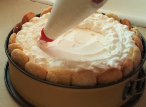 Piping whipped cream onto a Lemon Charlotte.